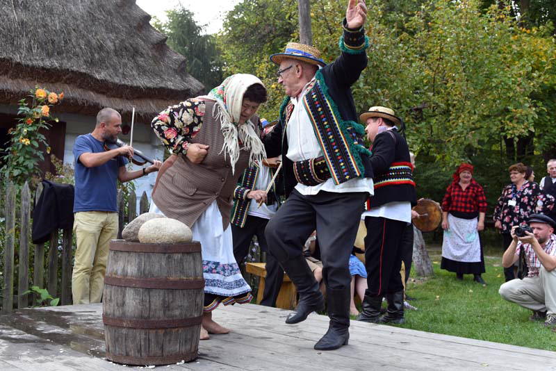 Zdjęcie tańczącej pary ubranej w dawne stroje ludowe.