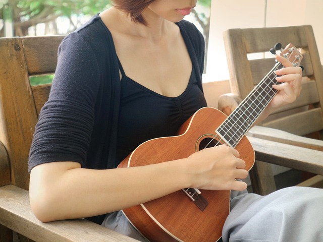 Zdjęcie pezedstawia dziewczynę grającą na ukulele.