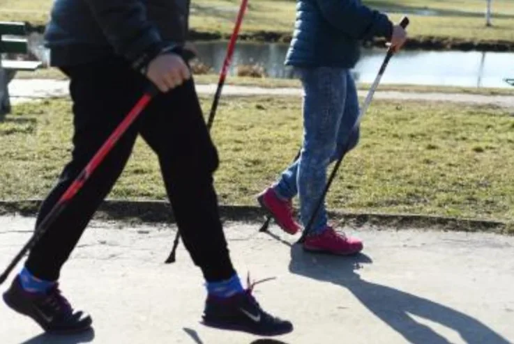 Zdjęcie nóg dwóch osób uprawiających nordic walking.