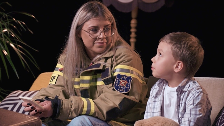 Zdjęcie kobiety i dziecka, małego chłopca, siedzących na kanapie.