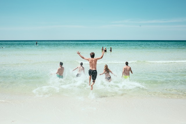 Zdjęcie kąpiących się przy plaży ludzi.