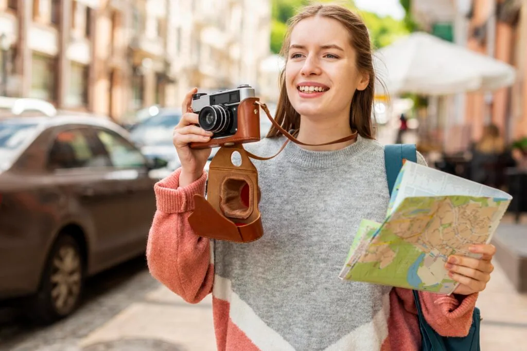 Zdjęcie dziewczyny z aparatem fotograficznym i mapą.