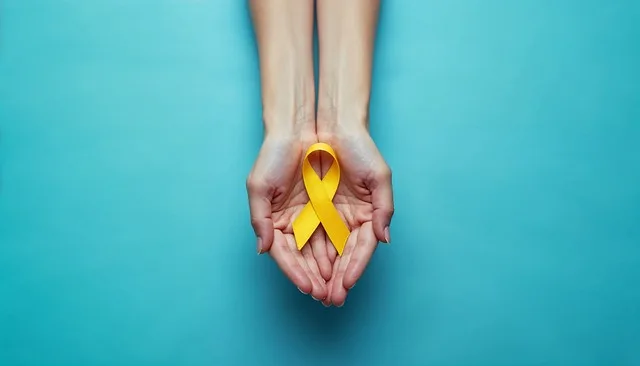 Zdjęcie dłoni z położoną na nich symboliczną żółtą wstążką