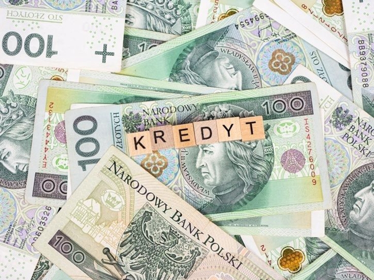 Banknoty, na których widnieje napis KREDYT utworzony z drewnianych klocków.