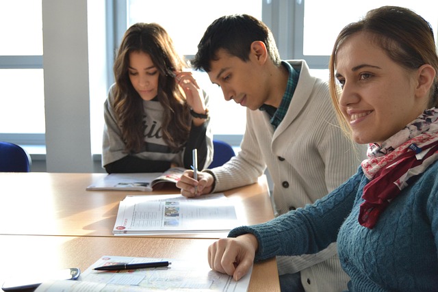 Studenci przy stole z materiałami edukacyjnymi